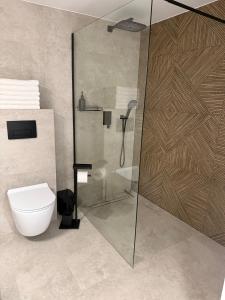 a bathroom with a glass shower with a toilet at Apartament u Bacy in Nowy Targ