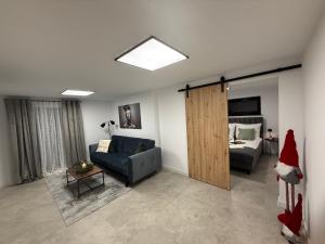 a living room with a couch and a bed at Apartament u Bacy in Nowy Targ