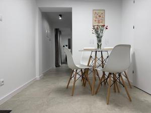 a dining room with a table and white chairs at Apartament u Bacy in Nowy Targ +9 photos