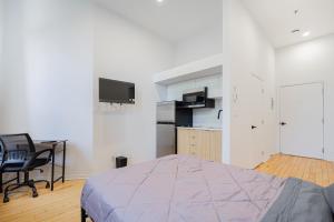 ein Schlafzimmer mit Bett und Schreibtisch und eine Küche in der Unterkunft Sunny Corner studio for 2 Guest with Parking in Montreal
