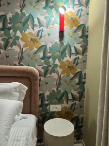 a bedroom with a wall with a flowery wallpaper at 603 Apartments in Baddah