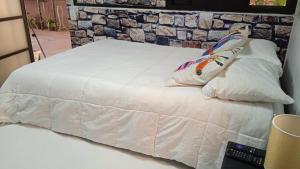 a white bed with a pillow on top of it at Hyperrent habitaciones in Xalapa