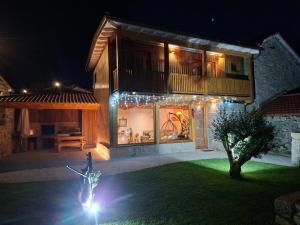 una casa con luces en el patio por la noche en Casa Carballo, en Puxedo
