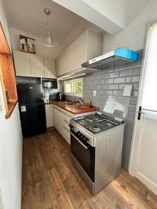 una cocina con estufa y refrigerador en Casa a 3 cuadras del mar- Piriápolis, en Piriápolis 1 foto más