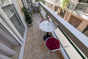 a balcony with a table and a red chair at Danellgio cozy nest apartment in Chalkida
