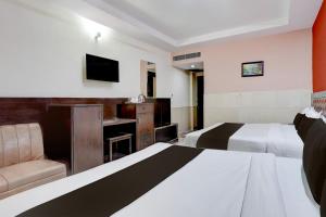 Una habitación de hotel con dos camas y un televisor. en Collection O Haridwar Railway Station Formerly Le Central, en Haridwar 28 fotos más