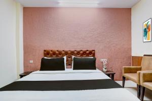 Un dormitorio con una cama grande y una pared roja. en Collection O Haridwar Railway Station Formerly Le Central, en Haridwar