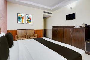 Una habitación de hotel con una cama y un televisor. en Collection O Haridwar Railway Station Formerly Le Central, en Haridwar