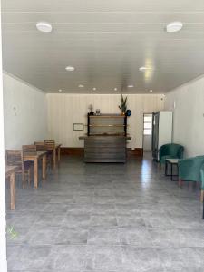 ein großer Raum mit Tischen und Stühlen sowie einem Tisch und einem Kühlschrank in der Unterkunft Copetonas in Nono
