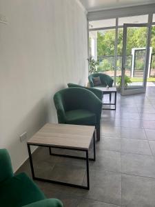 ein Wohnzimmer mit grünen Stühlen und einem Couchtisch in der Unterkunft Copetonas in Nono