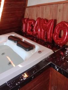 una vasca da bagno con vetro rosso sopra un bancone di Chale da Montanha Capivari a Campina Grande do Sul