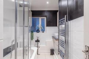 a bathroom with a tub and a toilet and a sink at Stylish Two-Bed Apartment in Ashford in Ashford