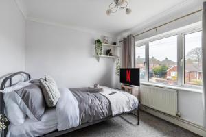 a white bedroom with a bed and a window at Stylish Two-Bed Apartment in Ashford in Ashford