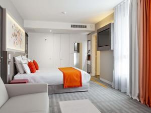 una camera d'albergo con un letto e un divano di Mercure Toulouse Sud a Tolosa Altre 124 foto