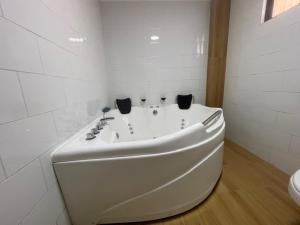 ein weißes Badezimmer mit Badewanne und Toilette in der Unterkunft Habitación doble con Jacuzzi in Curicó + 15 Fotos
