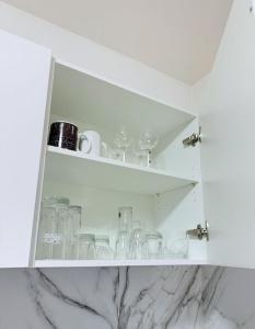 Seibel's SUITES - Exclusive Flat Krefeld City - GA - ROOFTOP في كريفيلد: خزانة بيضاء مع أكواب فيها