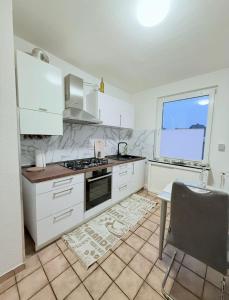 Seibel's SUITES - Exclusive Flat Krefeld City - GA - ROOFTOP في كريفيلد: مطبخ مع أجهزة بيضاء وطاولة ونافذة