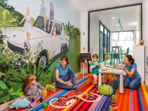 Un grupo de niños en una habitación con un mural de una furgoneta. en ibis Styles Budapest Citywest, en Budapest