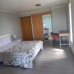 a hotel room with a bed and a table and a chair at casa2sonhos in Água de Pena