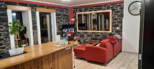 a red chair and a desk in a room with a wall at casa2sonhos in Água de Pena