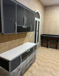 Almajidy Villa في القاهرة: مطبخ فارغ مع خزائن سوداء وبيانو