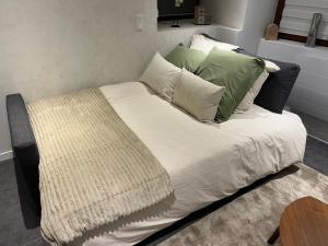 ロウファッハにあるSand & Chill - Studio 37Rのベッド(緑と白の枕付)