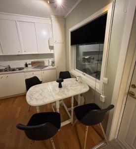 a kitchen with a table and chairs and a window at Strandveien apartment in Narvik +11 photos