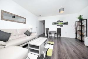 a living room with a white couch and a table at Stunning 2BR flat with balcony in Maidenhead