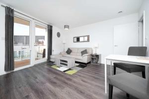 a white living room with a couch and a table at Stunning 2BR flat with balcony in Maidenhead