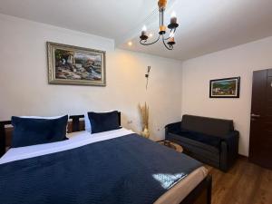 a bedroom with a large bed and a couch at Hotel Fjor in Prizren