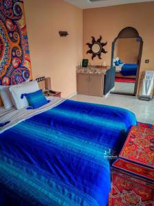 Chefchaouen Bedroom - Traditional Moroccan : غرفة نوم مع سرير أزرق كبير مع مرآة