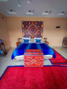 Chefchaouen Bedroom - Traditional Moroccan : غرفة نوم بسرير كبير مع سجادة حمراء +صورة واحدة