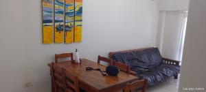 Un comedor con una mesa y un sofá. en Brisas, en Santa Teresita