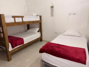 two bunk beds in a room with a red blanket at Apartamento completo in Santa Marta