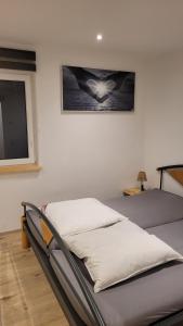 un lit dans une chambre avec un tableau sur le mur dans l'établissement Ferienappartement Talblick, à Hohnstein