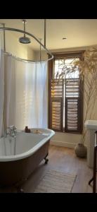 eine Badewanne im Bad mit Fenster in der Unterkunft Sunray House - Sea View, 20m from the Beach in Felixstowe + 6 Fotos