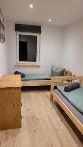 une chambre avec trois lits et une fenêtre dans l'établissement Ferienappartement Talblick, à Hohnstein