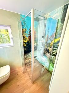 bagno con doccia e dipinto sul muro di Chalet im Wald mit Sauna a Schönwalde Altre 18 foto