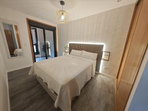 a bedroom with a large white bed in a room at Doña Urraca in Porriño