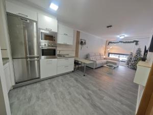 a white kitchen with a couch and a table at Doña Urraca in Porriño +13 photos