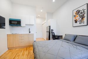 une chambre avec un grand lit et une cuisine dans l'établissement Relaxing Studio for 2 Guest with parking, à Montréal