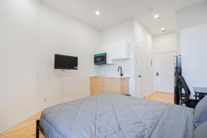 une chambre avec un lit et une télévision au mur dans l'établissement Relaxing Studio for 2 Guest with parking, à Montréal