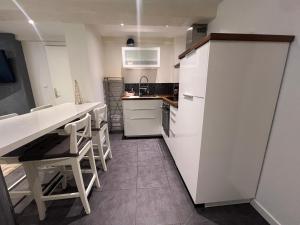 ロウファッハにあるSand & Chill - Studio 37Rの白いキャビネットとテーブルと椅子のあるキッチン
