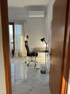 una habitación con un escritorio, una silla y una mesa en Athenas' Modern Oasis, en Kamena Vourla