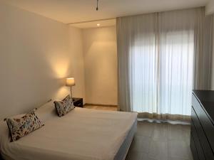 Grand Appart 3 chambres à 300 m de la Plage avec piscine et garage في تمارة: غرفة نوم بسرير كبير ونافذة +9 صور