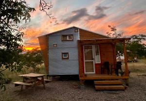 Una pequeña cabaña con una mesa de picnic y una puesta de sol. en Namakai.tinyhouse, minimalism in a magic place, en Los Árboles