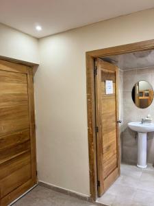 een badkamer met een wastafel, een toilet en een deur bij Bavaro Hostel in Punta Cana