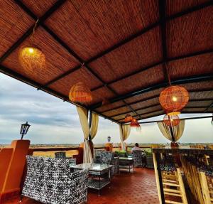 a patio with tables and chairs on a roof at Ferme Tynass - Amazigh Room Fes in Douar er Rouazi