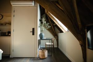 a room with a door and a table with a plant at Boutique hotel the Grand in Nijmegen