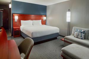 a hotel room with a large bed and a chair at Courtyard by Marriott Frederick in Frederick +20 photos